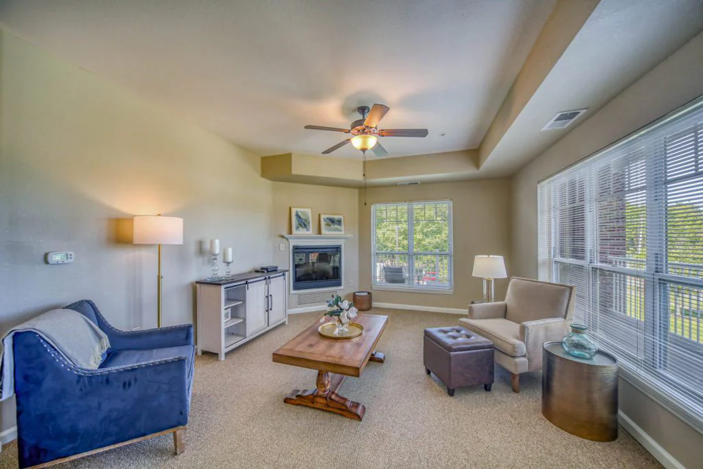 Living room area with blue and tan chairs, and a fireplace