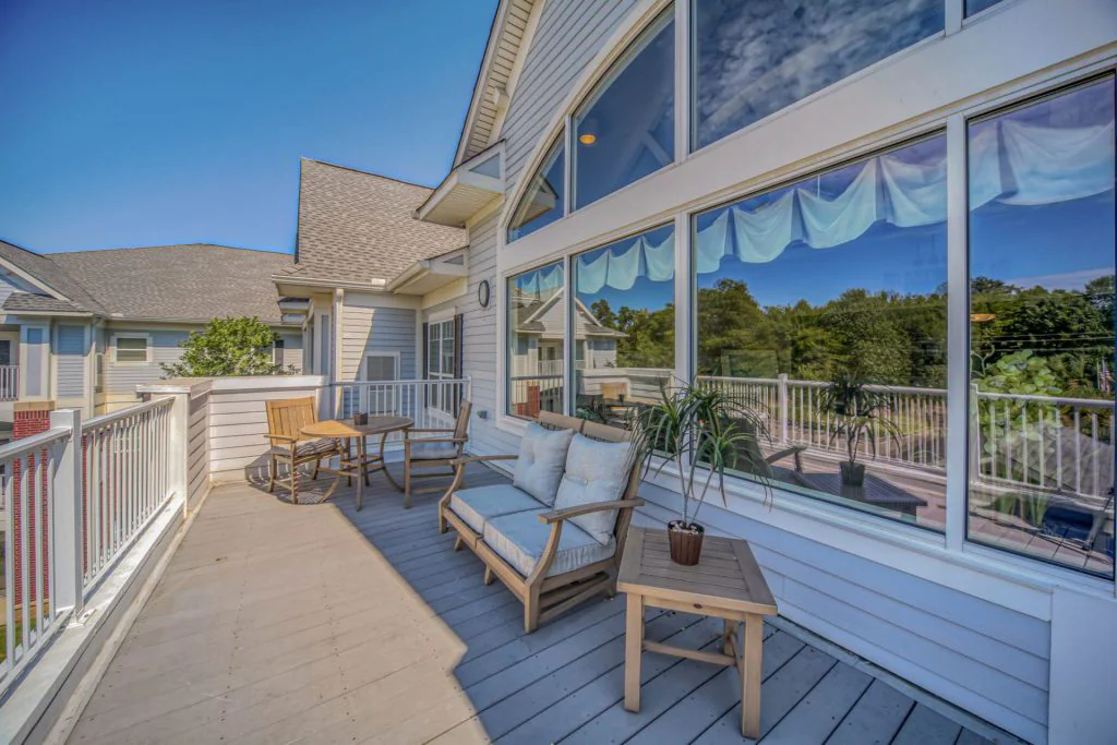 Balcony area with multiple tables, chairs and windows